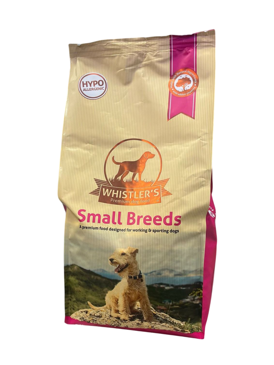 Bag of Whistler's Small Breeds dog food with a dog sitting on a rock in the mountains.