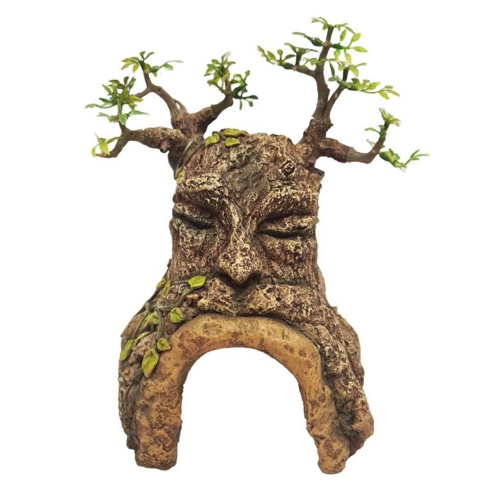 A decorative tree-of-life sculpture with a carved face, textured bark-like body, leafy branches at the top, and an arched base, shown on a plain white background.