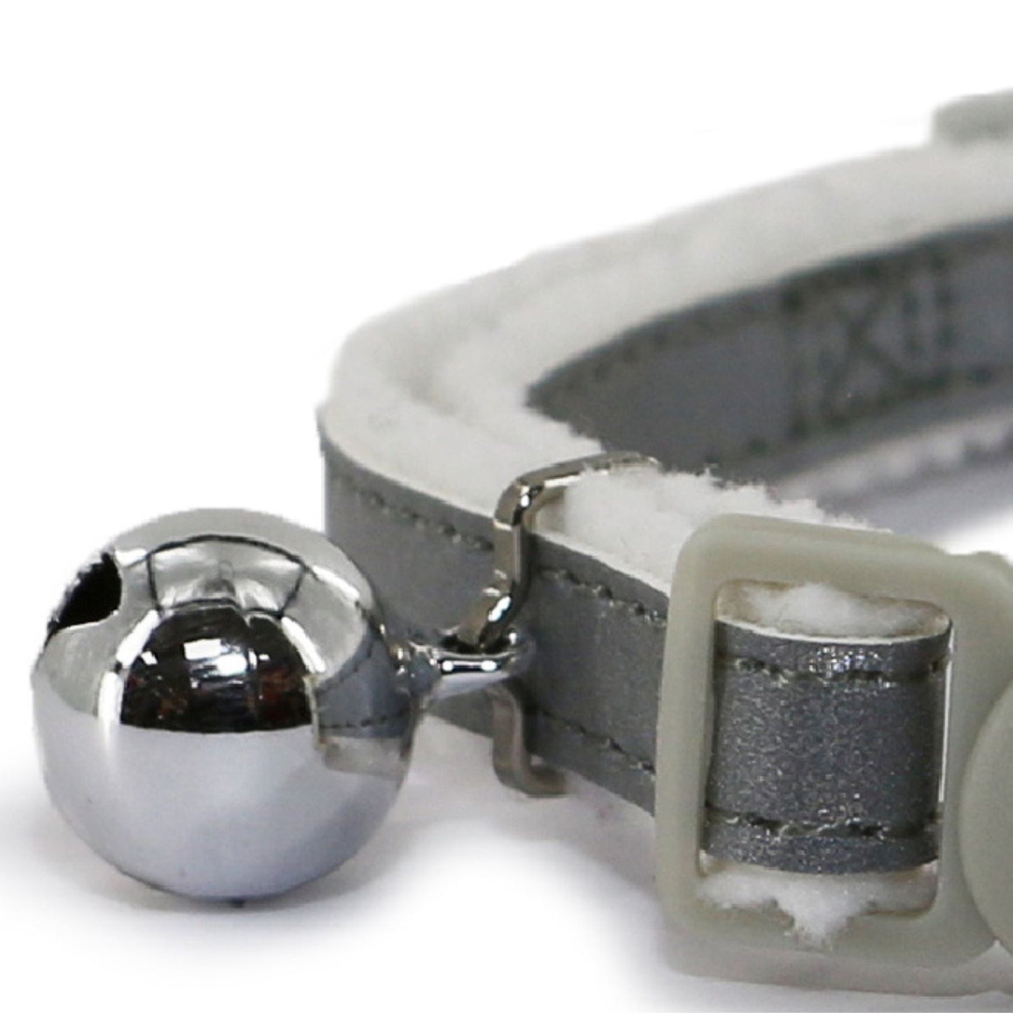 Close-up of a gray cat collar with a silver bell on a white background