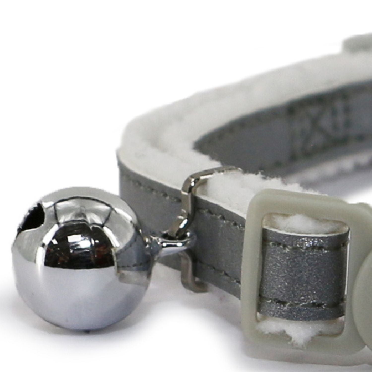 Close-up of a gray cat collar with a silver bell on a white background