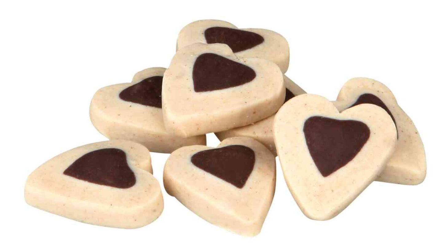 Heart-shaped dog treats with chocolate coloured centers on a white background
