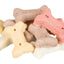 Assorted colored bone-shaped dog treats on a white background