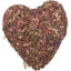 Heart-shaped small animal treat made of dried herbs on a white background