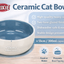 Trixie ceramic cat bowl with features listed on a wooden surface