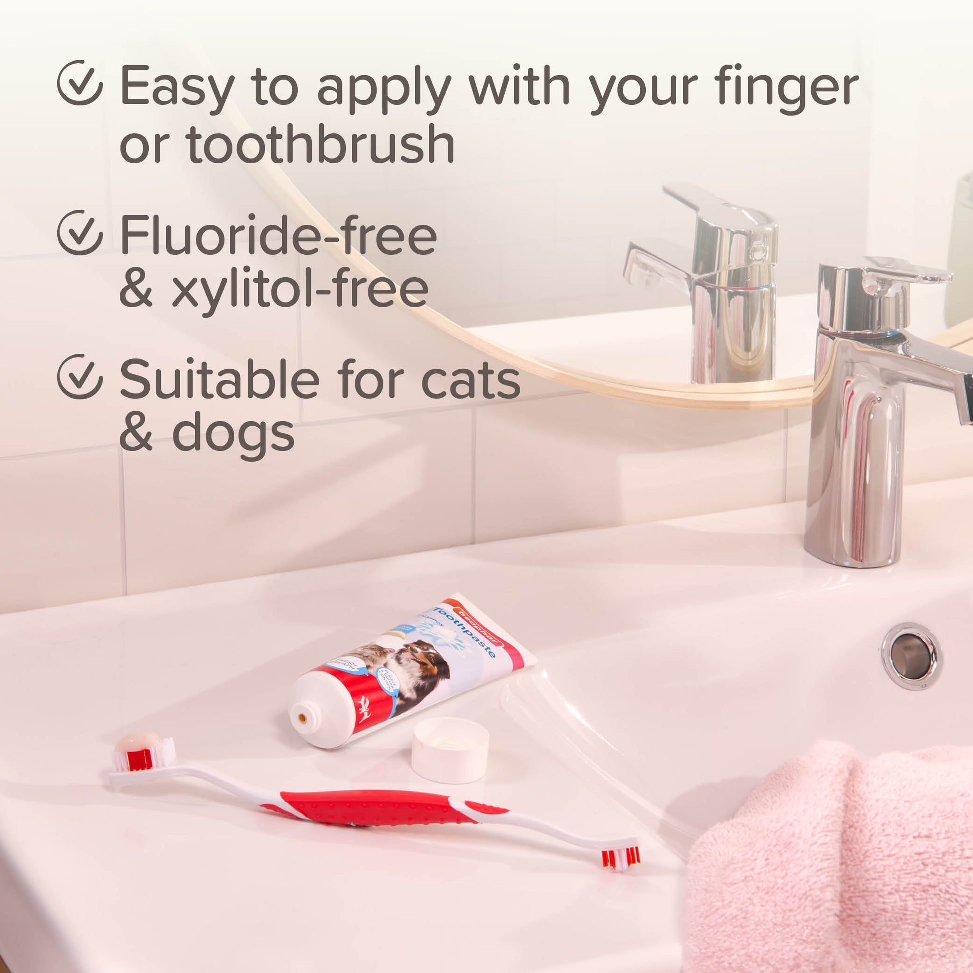 Cat and dog toothpaste with a toothbrush on a bathroom counter, featuring text about its use.