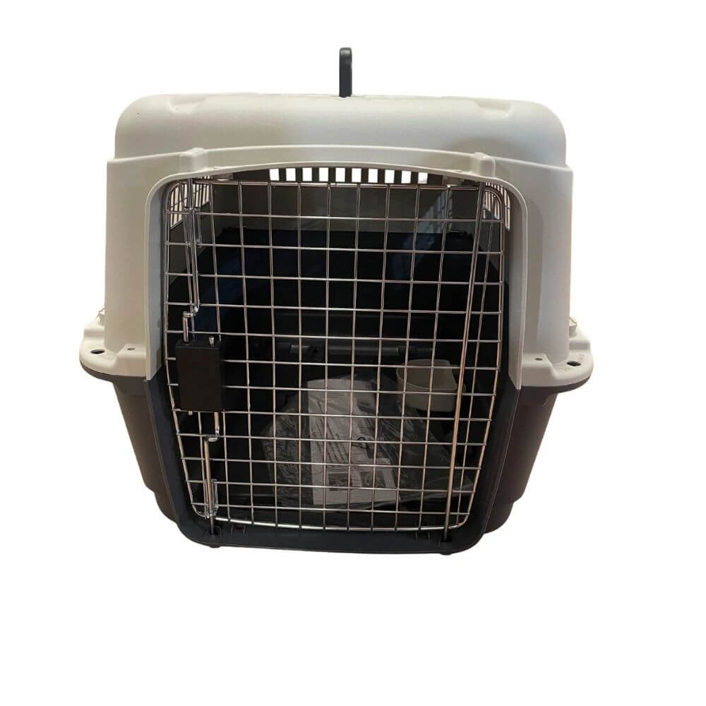 A plastic pet carrier with a white top lid, black base, and a silver metal wire door, shown against a plain white background. A carrier suitable for dogs and cats that is airline approved,  an aviation carrier.