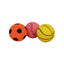 Three rubber dog toy balls in orange, pink, and yellow colors, resembling a soccer ball size, placed on a white background.