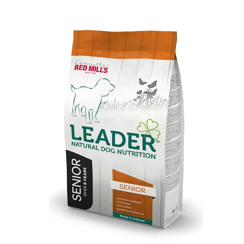 A bag of Red Mill's Leader Senior Natural Dog Nutrition dry dog food, featuring a white bag with orange top and bottom panels, green text, and a black vertical 'SENIOR' label.