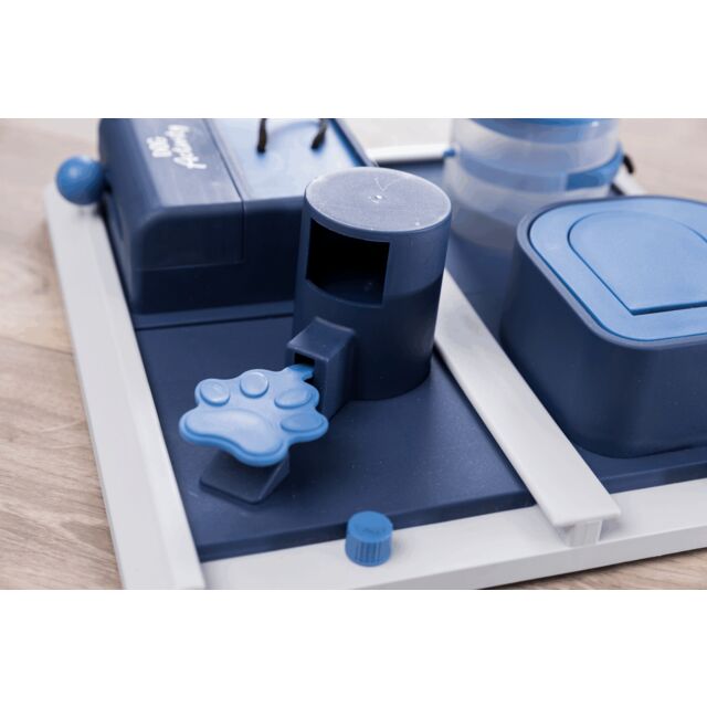 Blue and white dog puzzle with various accessories on a light wood floor.