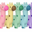 Five colorful giraffe-shaped dog toys in pink, yellow, green, blue, and purple on a gray background.