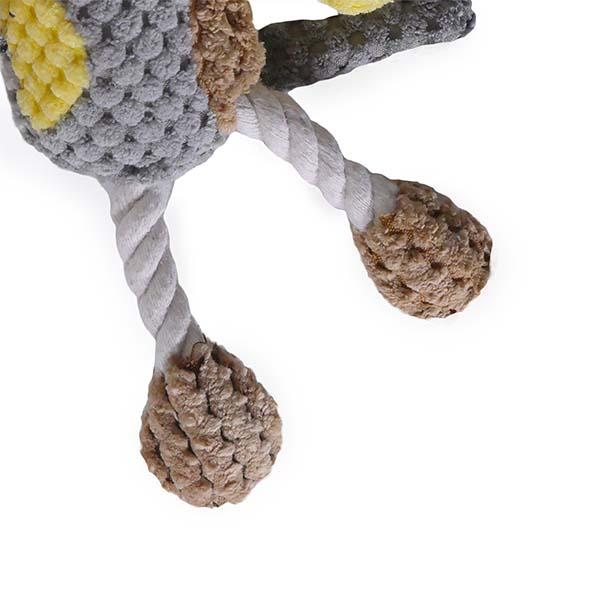 Close-up of a knitted dog toy with textured legs and a rope on a white background