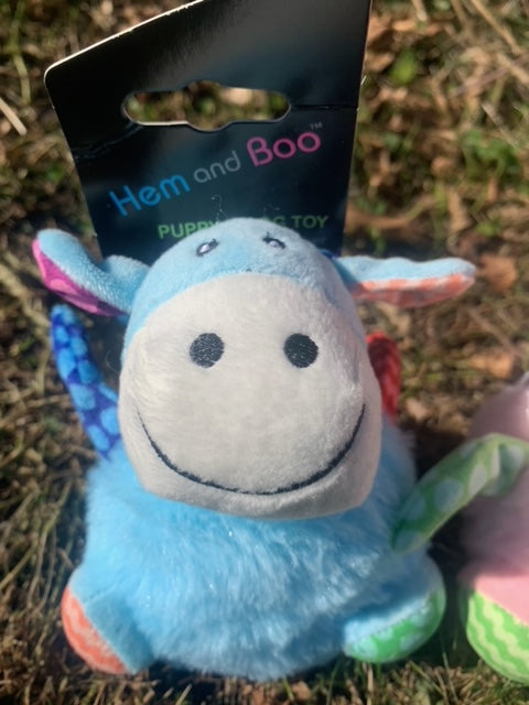 Blue plush toy with a tag labeled 'Hem and Boo' on a grassy background