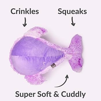 Purple plush dog toy fish with text indicating features like crinkles, squeaks, and softness on a white background.