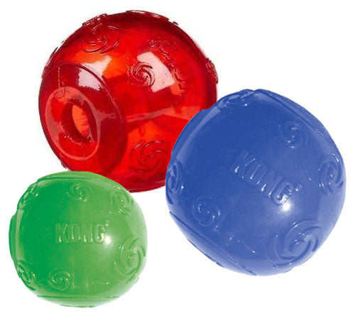 Three KONG dog toys in red, blue, and green on a white background
