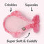 Pink plush dog toy with text indicating features like crinkles, squeaks, and softness on a white background.