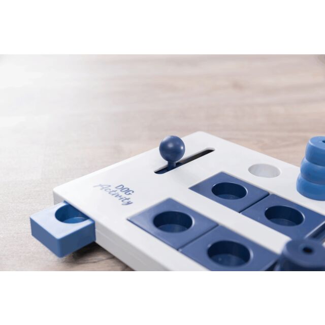 Blue and white puzzle dog toy on a light wooden surface