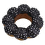 Black donut dog toy with white spikes on a white background