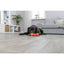 Dog playing with a toy on a wooden floor in a living room.