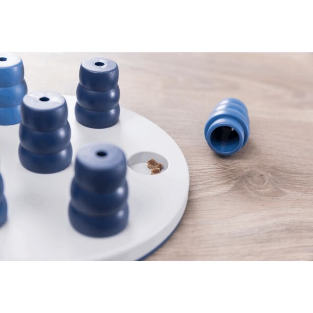 Blue cylindrical objects on a white circular base with a wooden surface background dog game