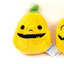 Plush dog toy resembling a yellow fruit with a face on a white background