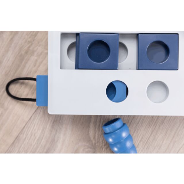 White and blue dog toy with holes on a wooden surface