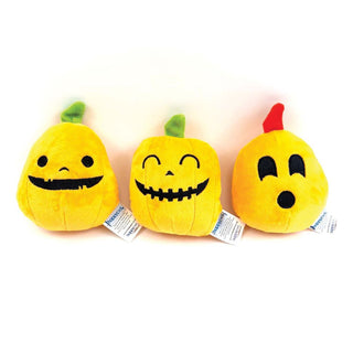 Three yellow plush pumpkin dog toys with smiling faces on a white background