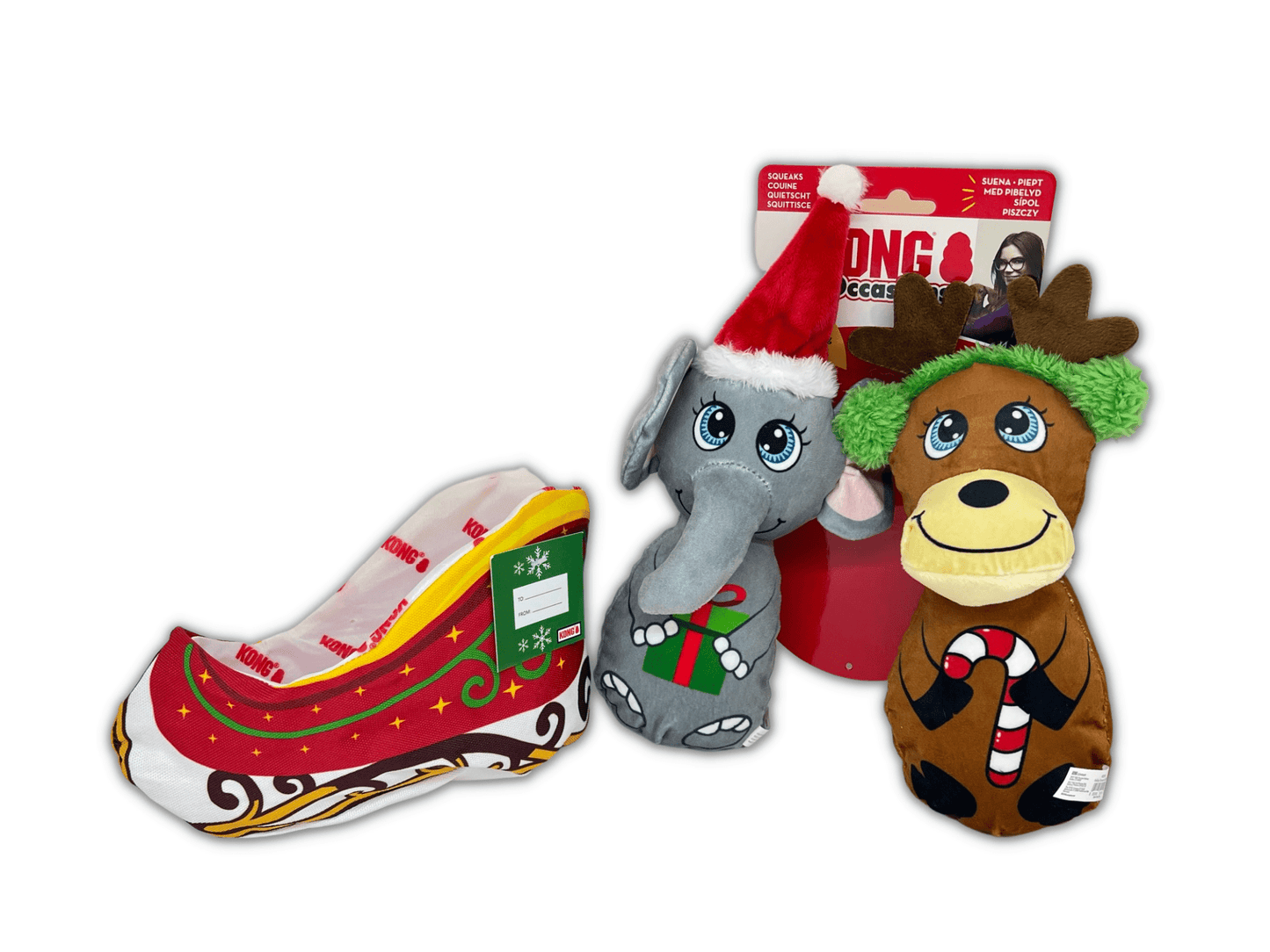 Set of Christmas-themed dog toys including a reindeer, elephant, and shoe-shaped toy on a white background.
