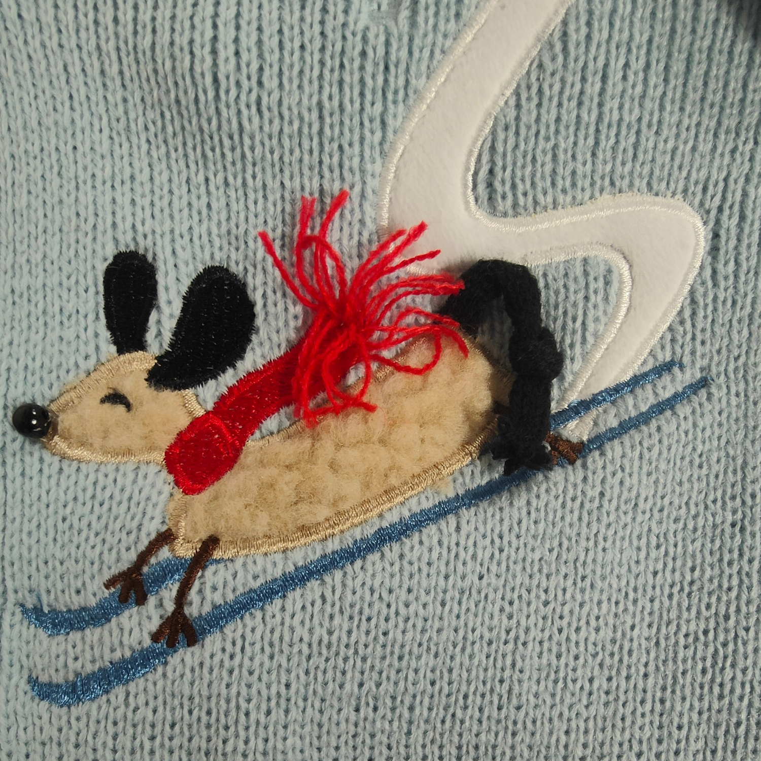 Embroidered dog with a red scarf on a textured fabric background