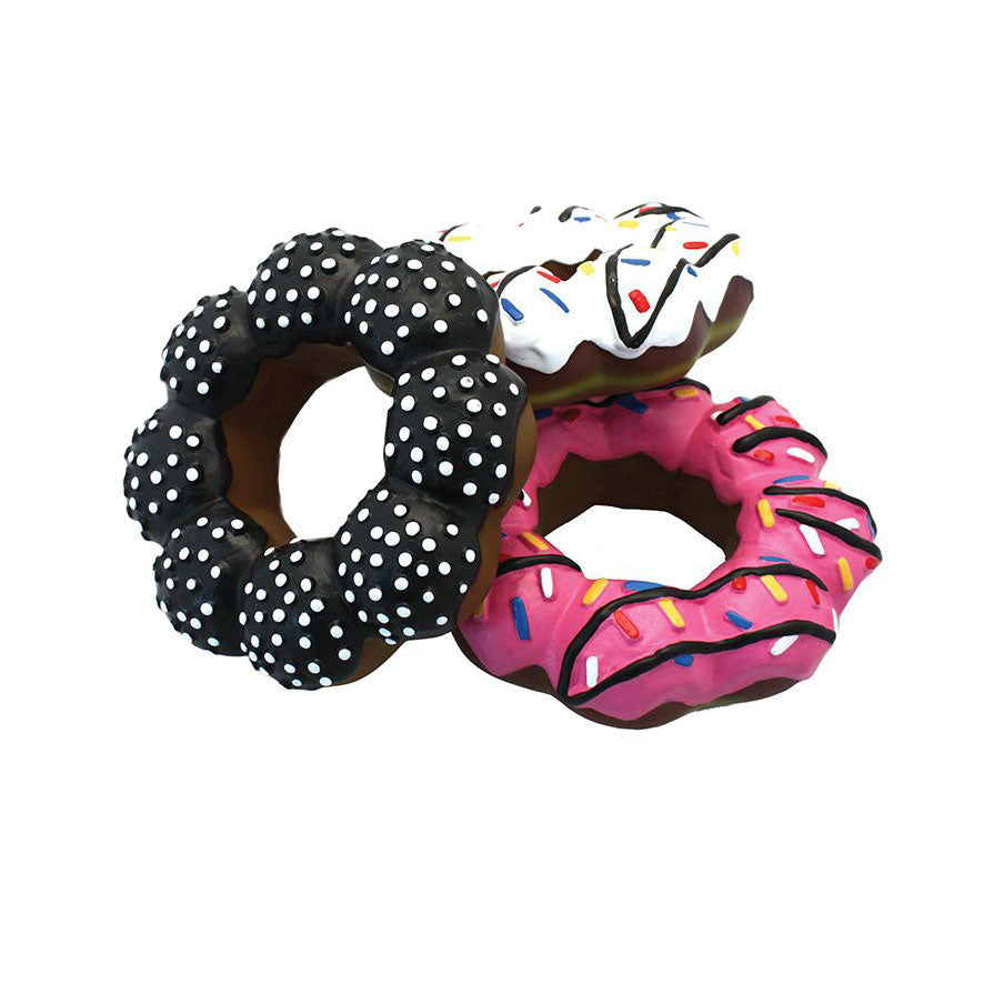 Three donut-shaped dog toys with polka dots, white icing, and pink icing with sprinkles on a white background.