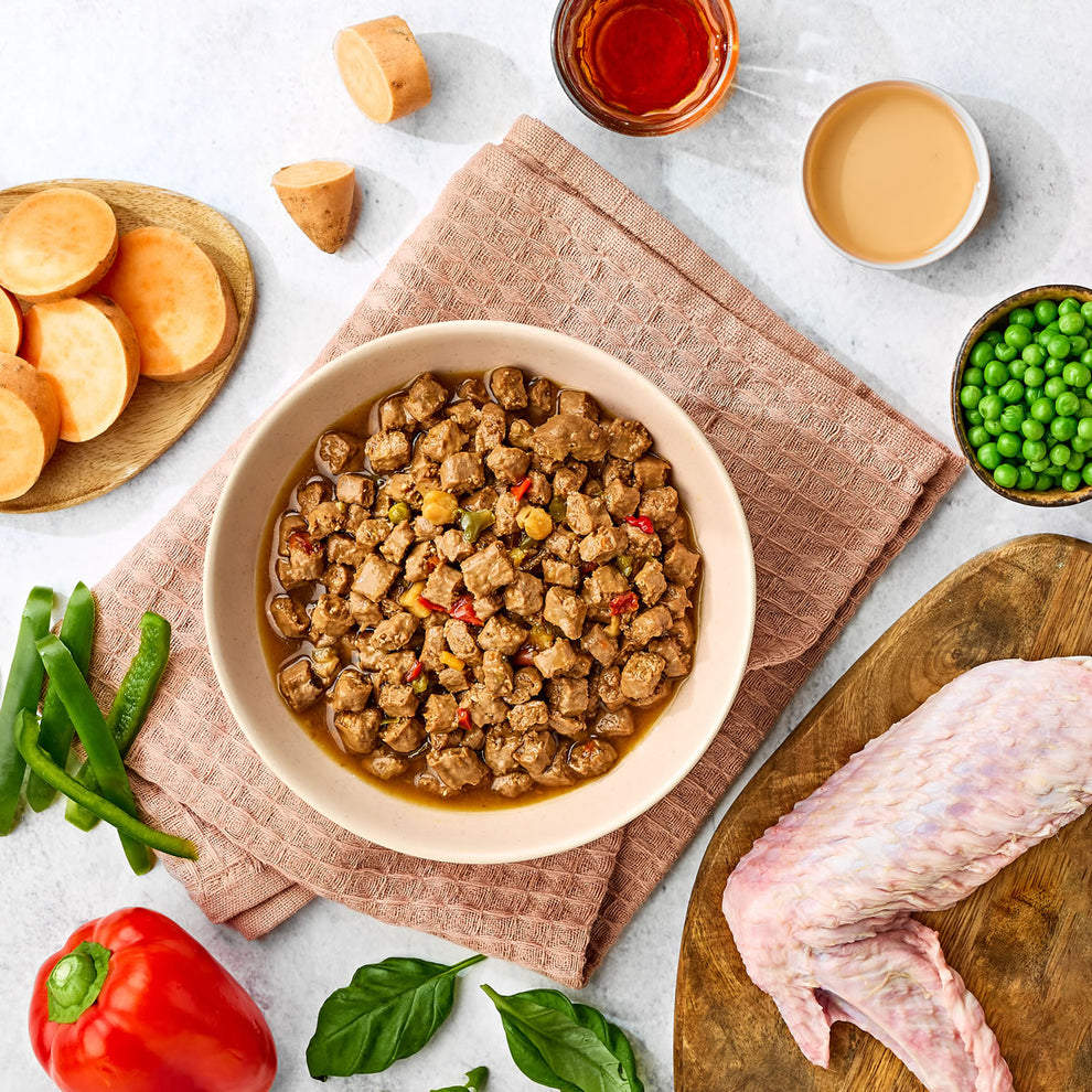 Bowl of cooked meat dish with ingredients on a table